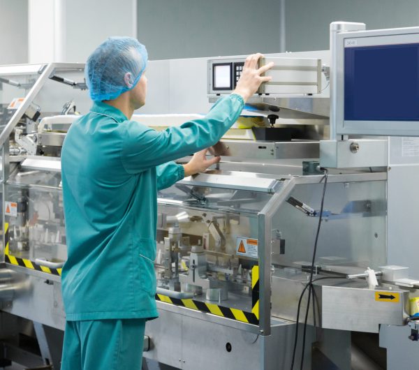 Pharmaceutical technician in sterile working conditions at pharmacy industry